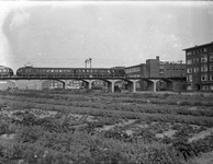 806684 Gezicht op het spoorviaduct (voormalig Z.H.E.S.M.-viaduct) over de Gordelweg te Rotterdam, met een trein ...